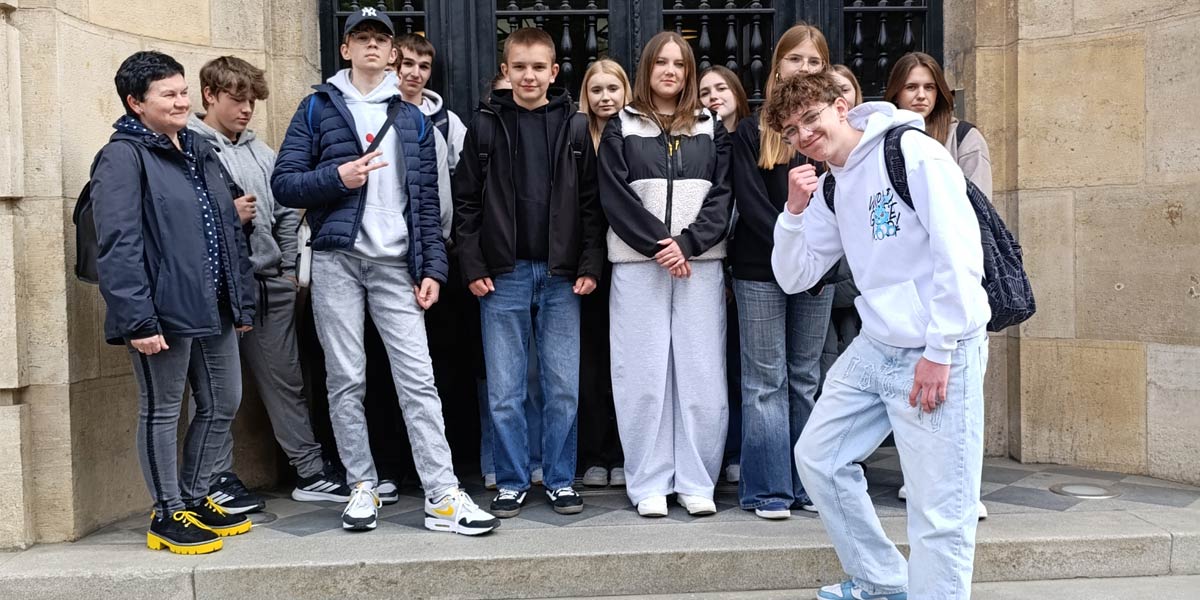 Uczniowie stoją przed budynkiem