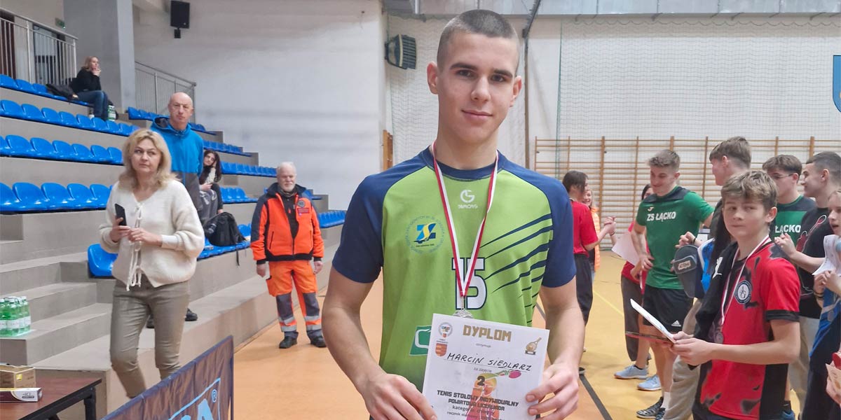Uczeń stoi z dyplomem