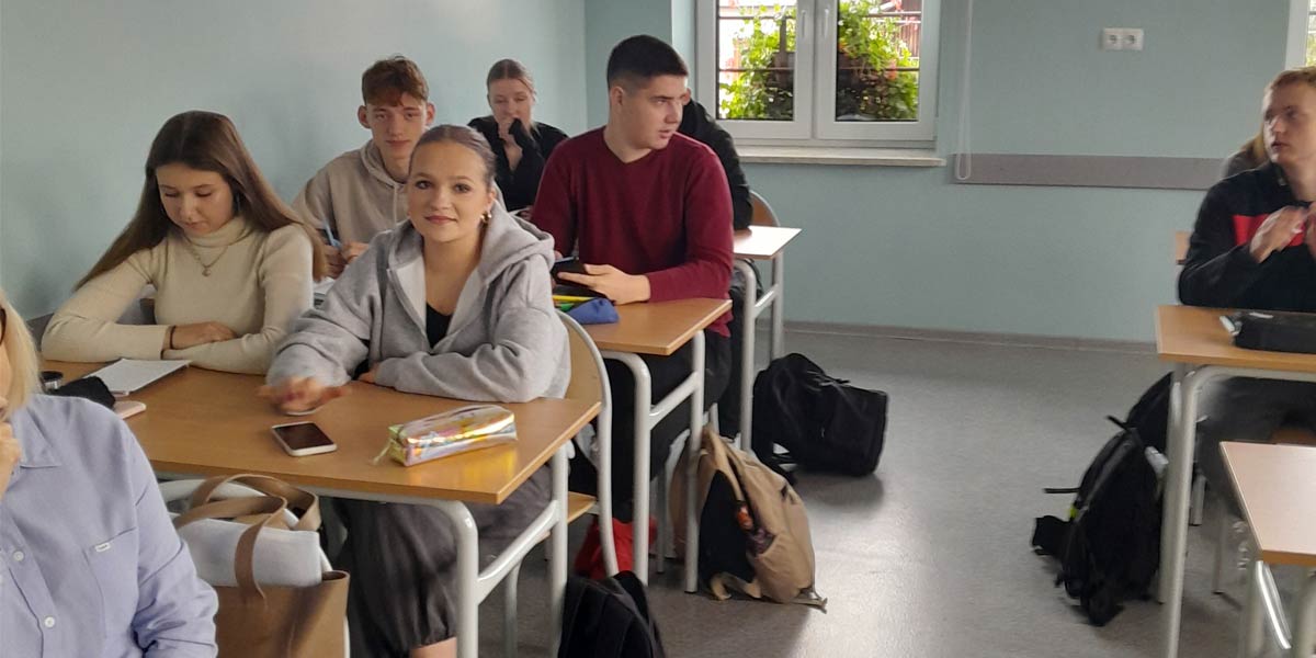 Uczniowie siedzą w sali