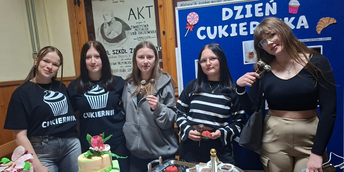 Młodzież przy stoisku z ciastkami.