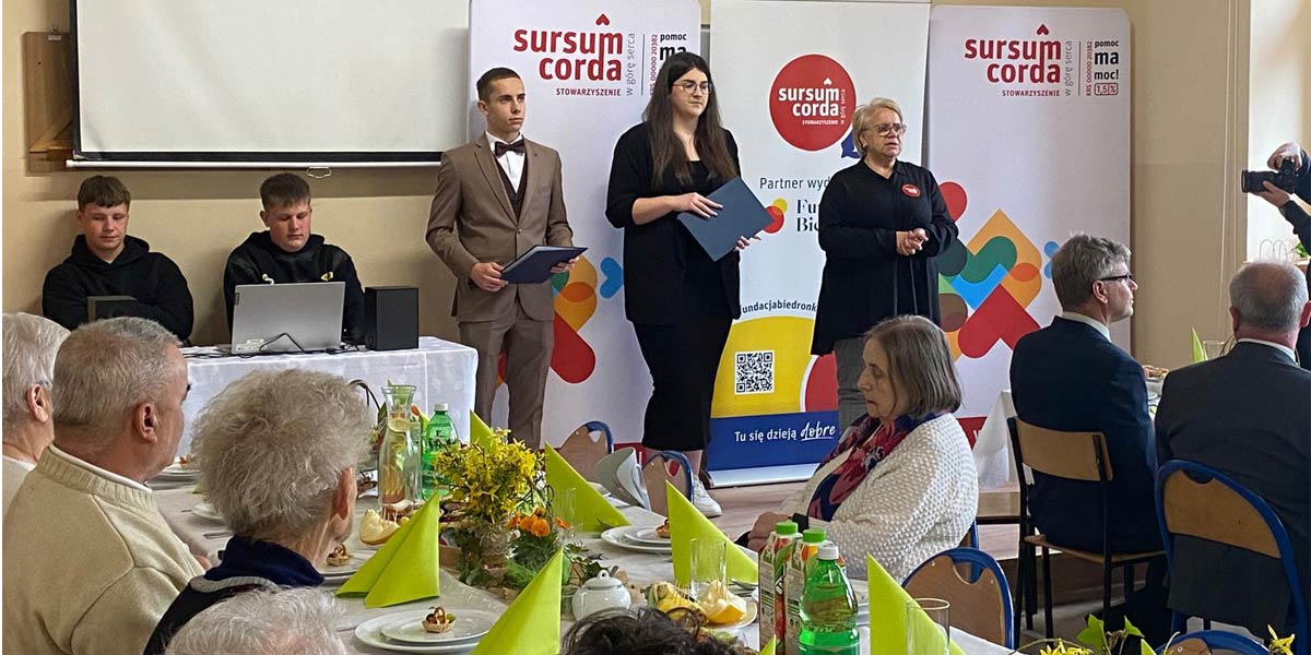 Seniorzy siedzą przy stole.